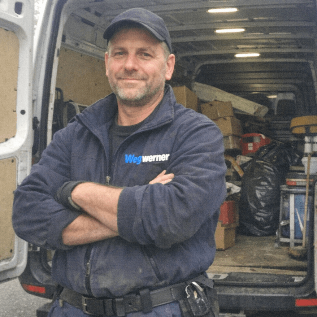 Zwei Räumungsfachkräfte stehen vor einem Transporter in einer Wohnstraße in Halle